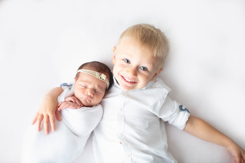 Newborn Photography, brother cuddling up with new baby
