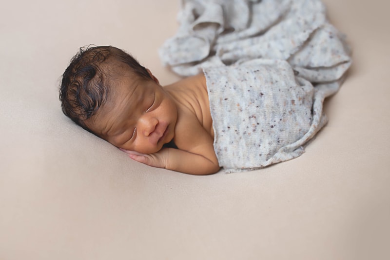 Newborn Photography, baby laying on a tan blanket