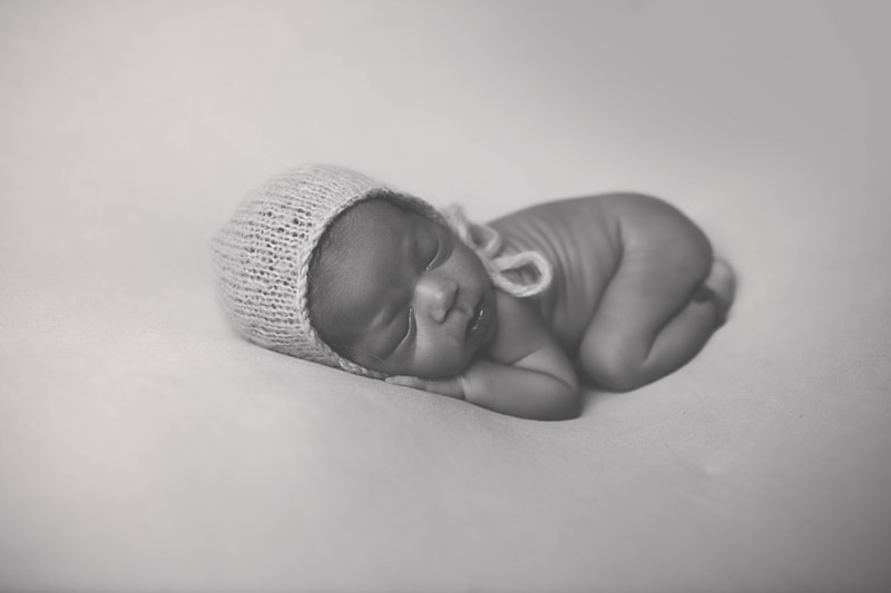 Newborn Photography, black and white of baby sleeping with bonnet