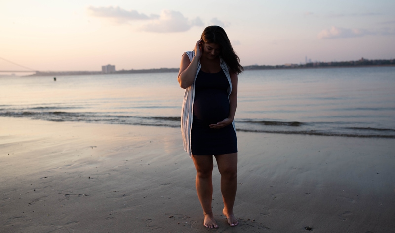 Maternity Photography, mother holding her belly next to the ocean