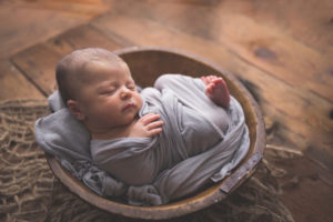 Lacey Cooper Photography, newborn baby wrapped up and resting in a wooden bowl